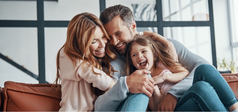 Family laughing together on a couch